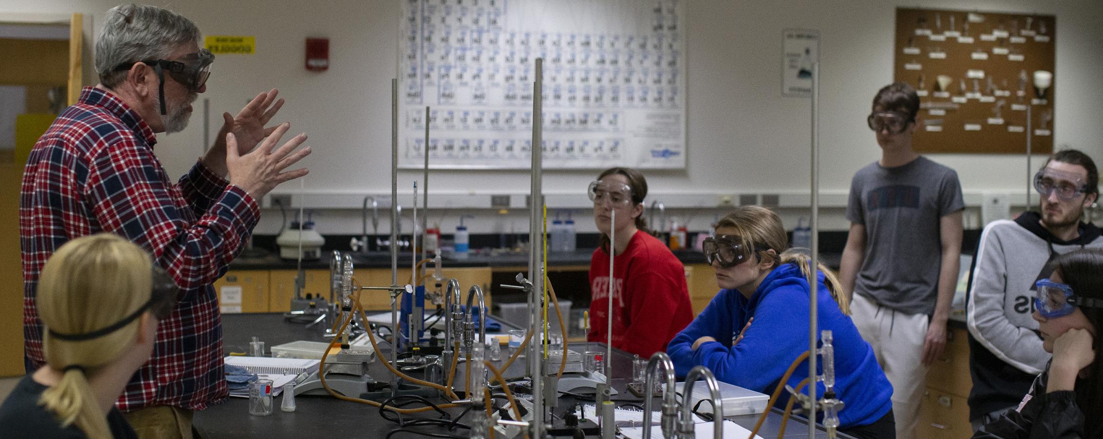 Students gather around a chemistry faculty member.