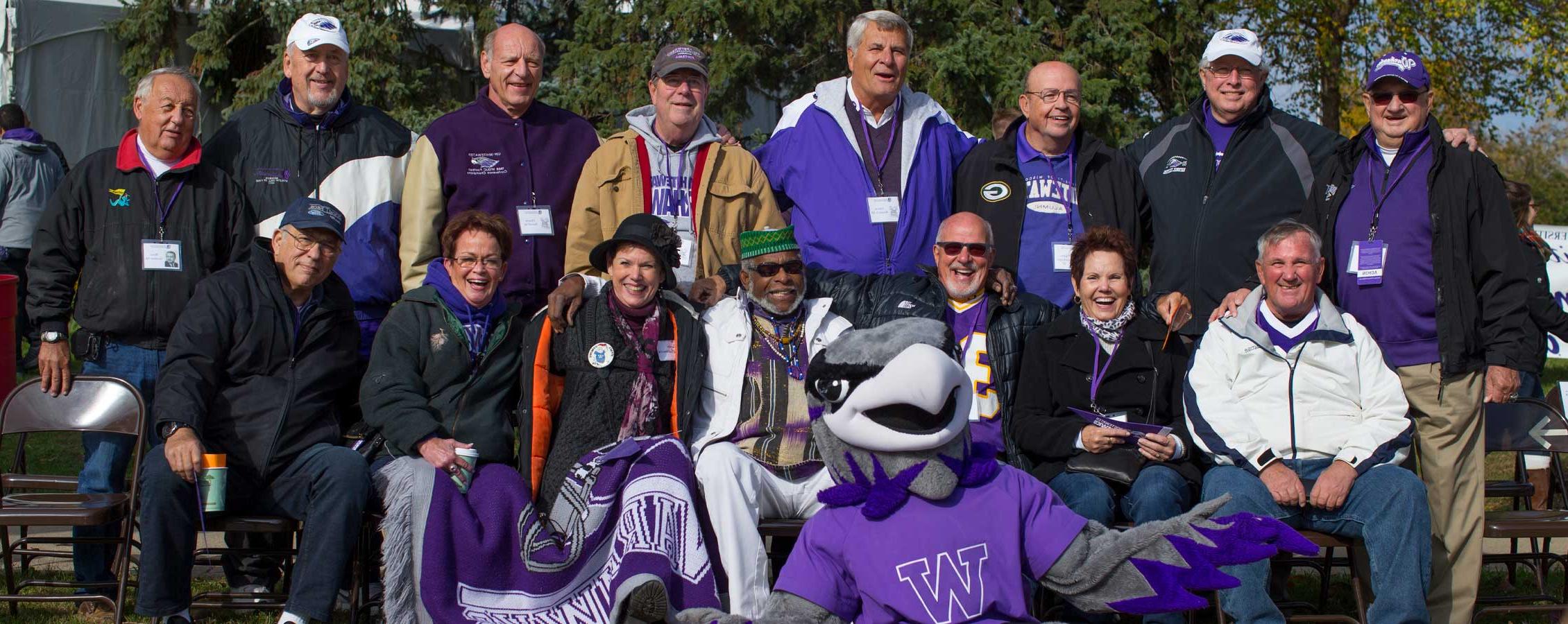 Homecoming Alumni sit with Willie Warhawk.